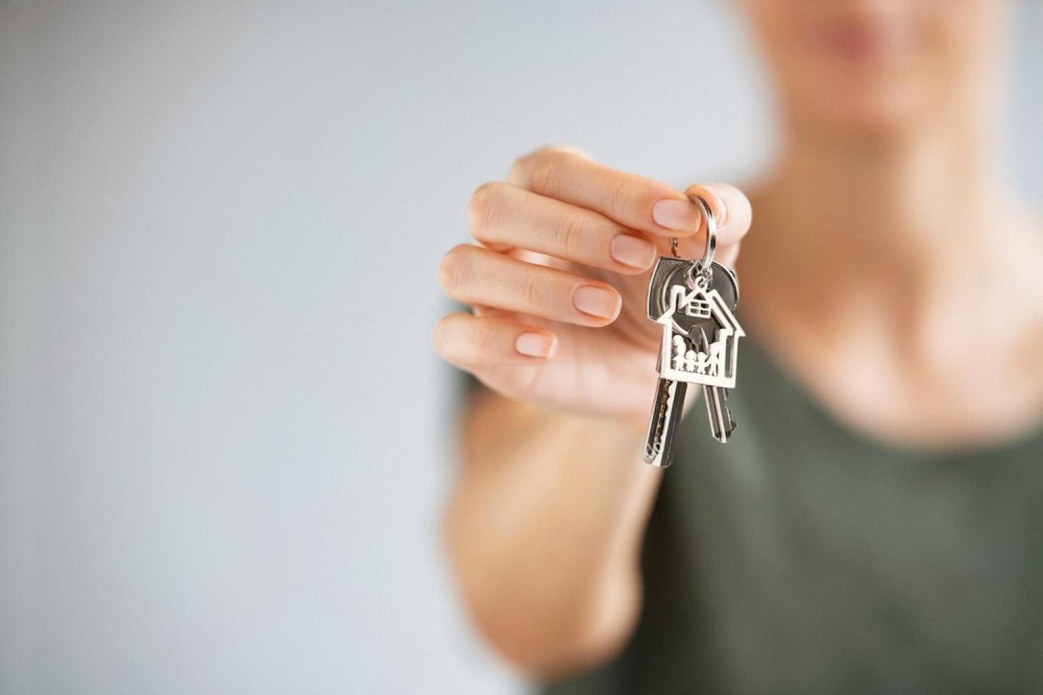 Woman holding house-shaped keys, symbolising home insurance for Dubai property owners