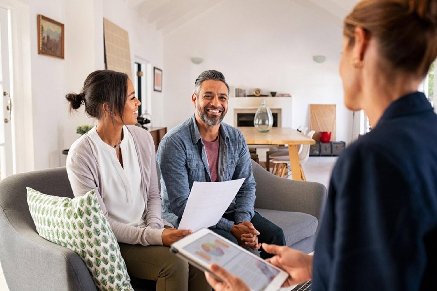 Couple discussing home insurance coverage with an advisor in a Dubai living room