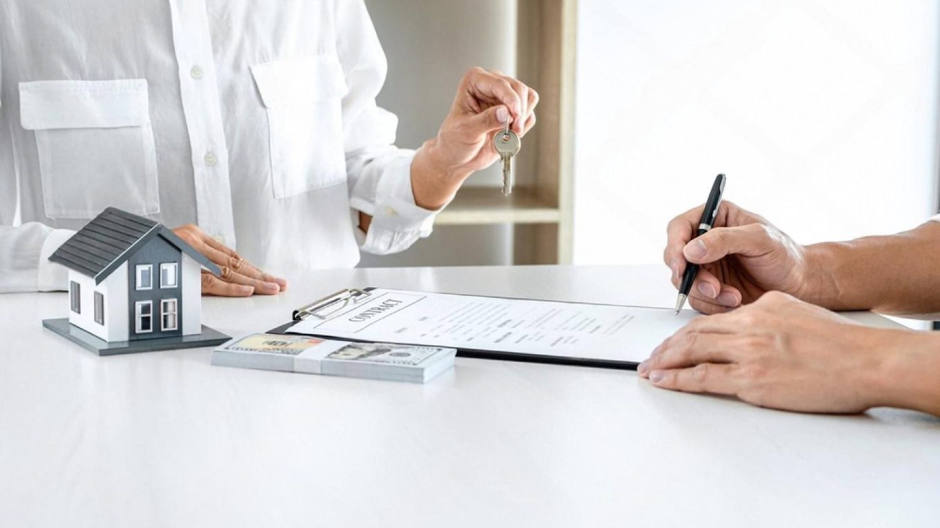 Real estate agent handing over keys and signing a Dubai property insurance contract